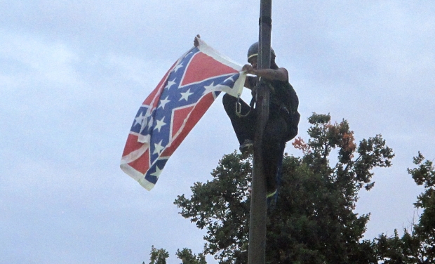 Bree Newsome of Charlotte, N.C., removes the Confederate battle flag at a Confederate monument at the Statehouse in Columbia, S.C., on Saturday, June, 27, 2015. She was taken into custody when she came down. The flag was raised again by capitol Bree Newsome of Charlotte, N.C., removes the Confederate battle flag at a Confederate monument at the Statehouse in Columbia, S.C., on Saturday, June, 27, 2015. She was taken into custody when she came down. The flag was raised again by capitol